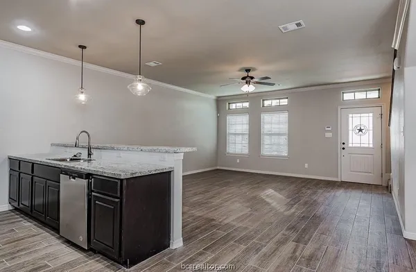 a kitchen with a sink a window and wooden floor