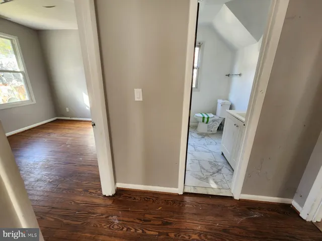 an empty room with wooden floor and a carpet