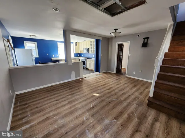 a view of a livingroom with wooden floor and stairs