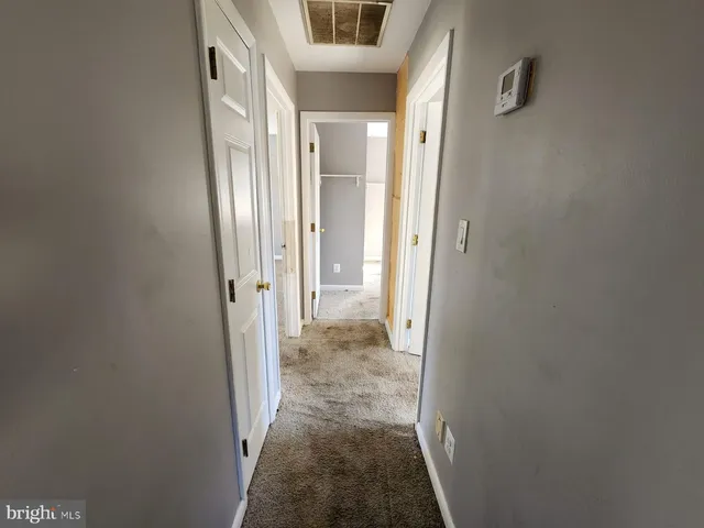 a view of a hallway with a livingroom and a bathroom