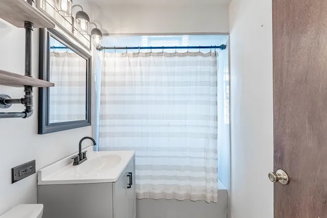 a bathroom with a sink a mirror and shower