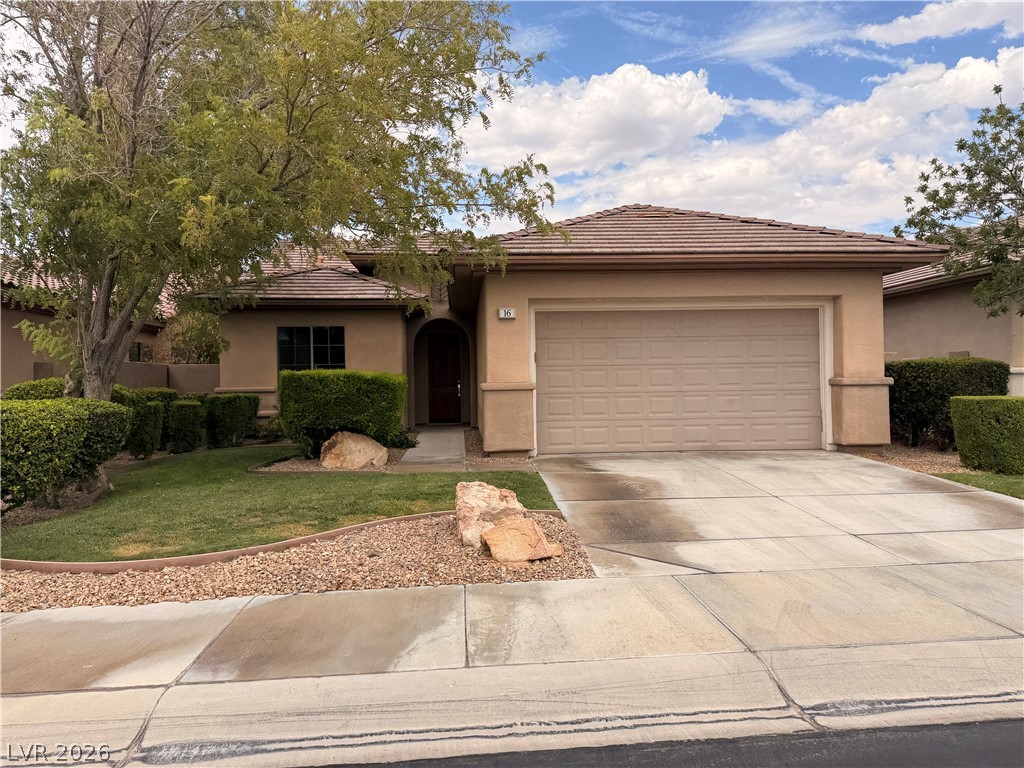 16 Caprington Road Henderson, NV 89052 - Photo 1 of 16 Classic desert landscaping and a concrete driveway lead to this stucco home with a tile roof.