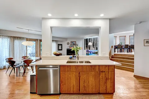 a view of a kitchen with kitchen island white cabinets and wooden floor