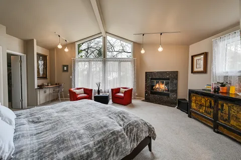 a bedroom with furniture and large windows