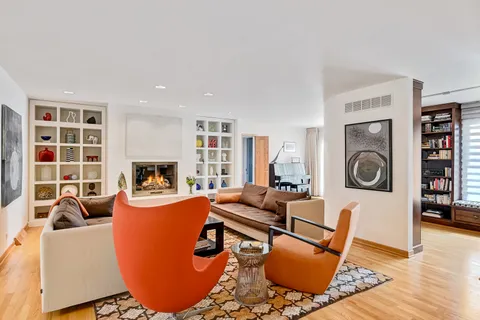 a living room with furniture a fireplace a rug and a large window