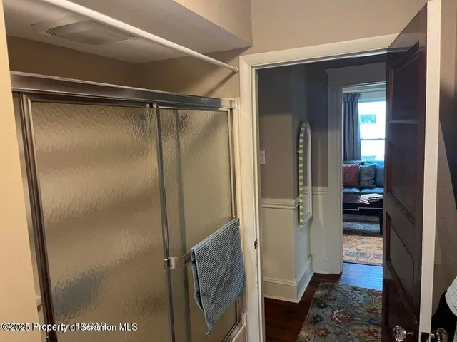 a bathroom with a glass door shower and a sink