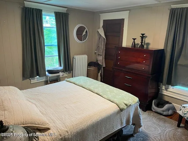 a bedroom with a bed and a mirror on dresser
