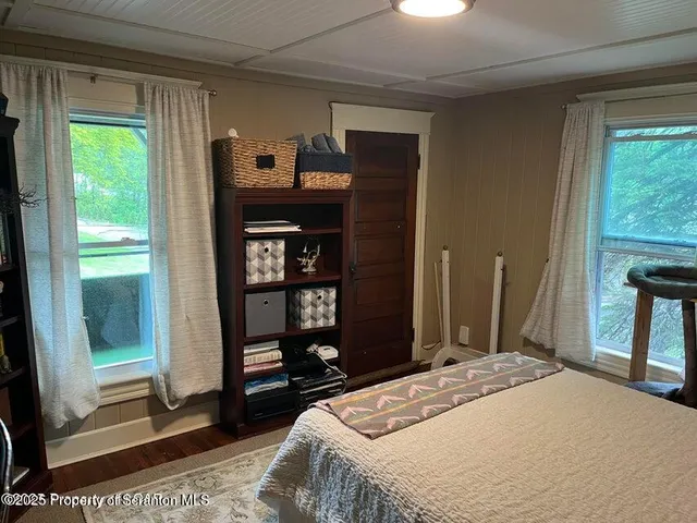 a bedroom with a bed and a dresser next to a window