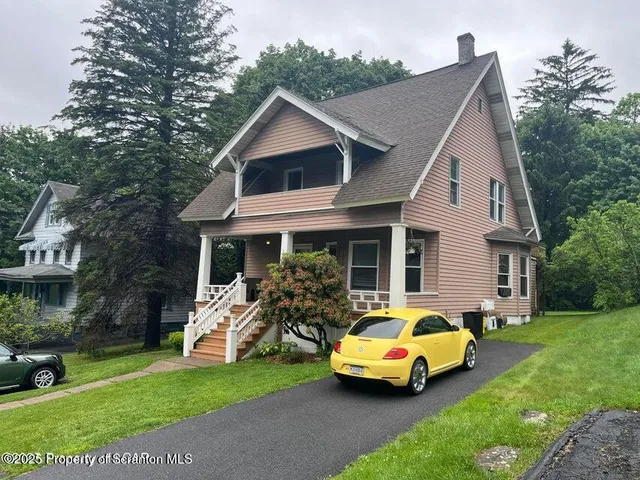 a car parked in front of a house with garden