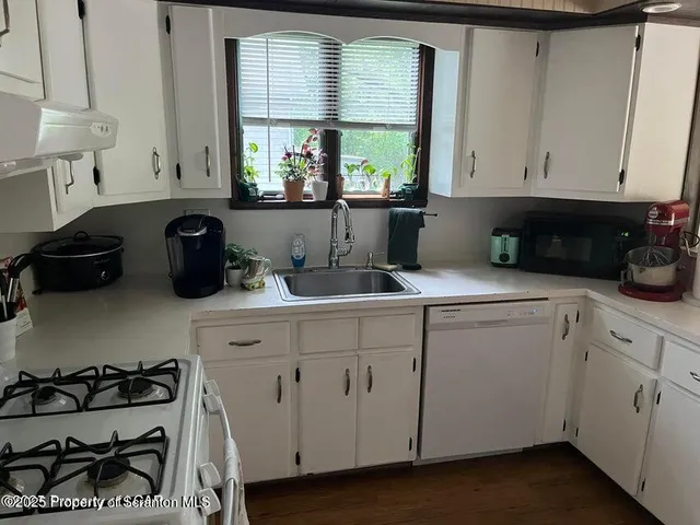 a kitchen with a sink a stove and cabinets