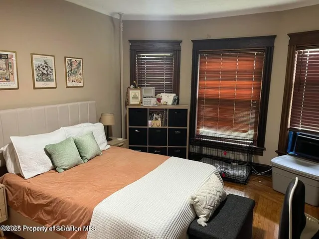 a bedroom with a bed and wooden floor