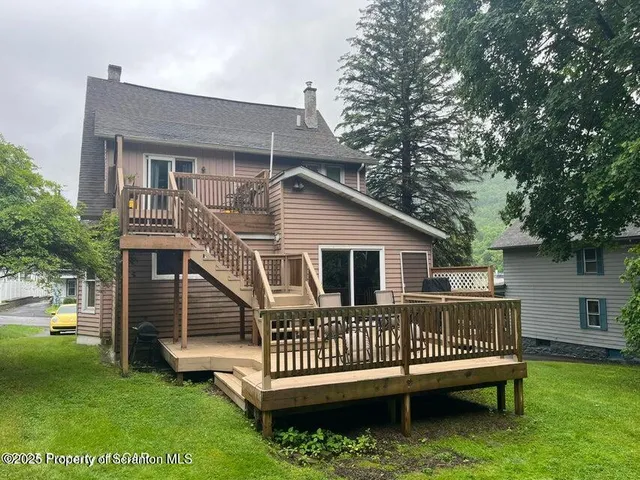 a view of a house with a deck and a yard