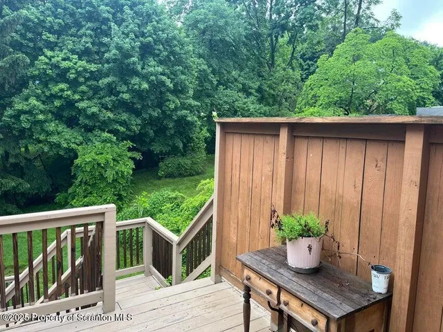 a balcony with wooden floor potted plants and wooden fence