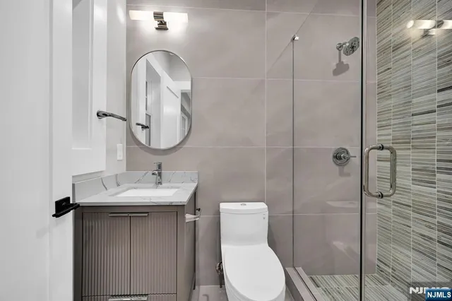 a bedroom with a bed and a lamp on dresser