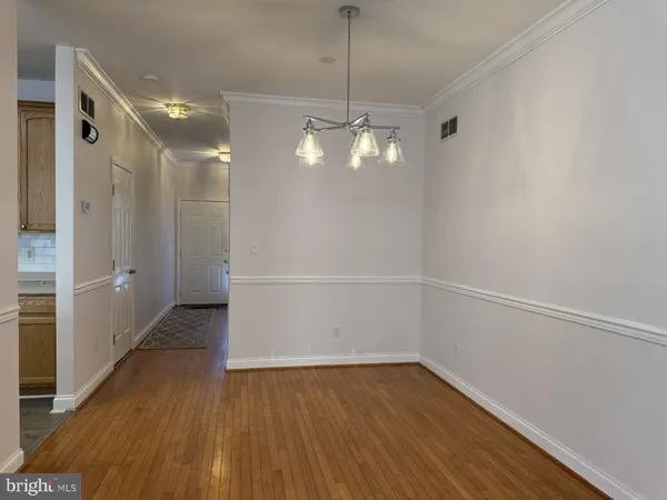 a view of a room with wooden floor and white walls