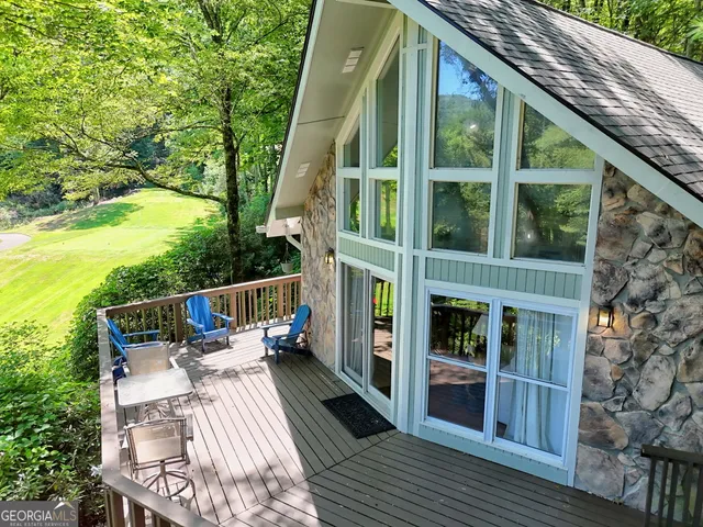 a balcony with wooden floor and outdoor seating