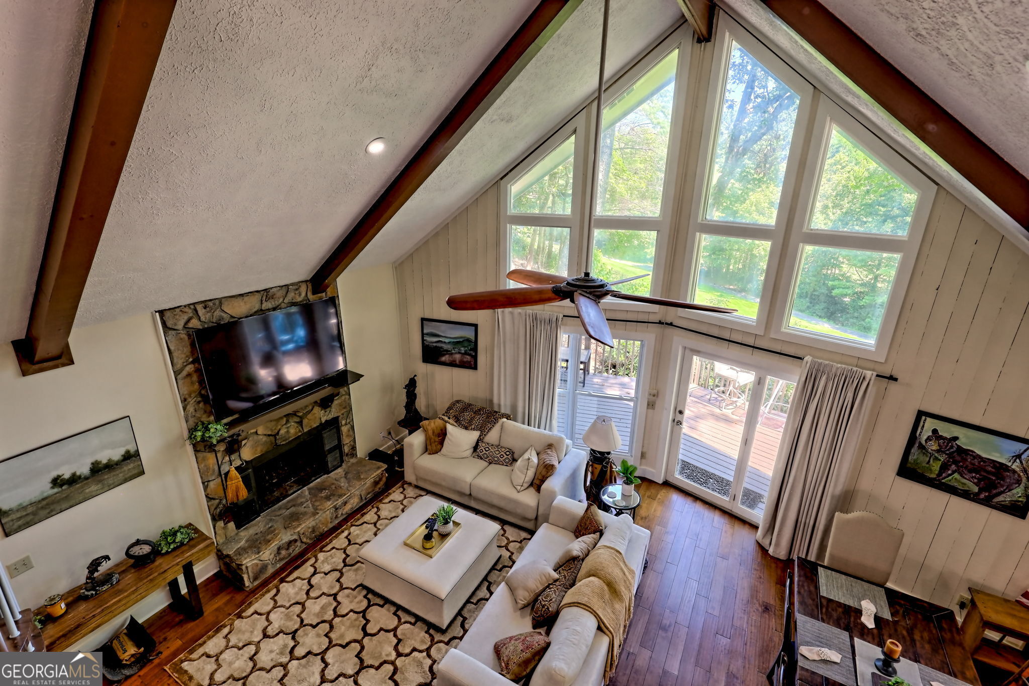 850 Ridgepole Drive Sky Valley, GA 30537 - Photo 50 of 73 a living room with furniture a flat screen tv and a floor to ceiling window
