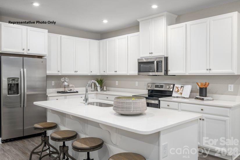 2308 Flicker Road, Unit 1046A Indian Land, SC 29707 - Photo 3 of 15 a kitchen with a sink a stove and white cabinets