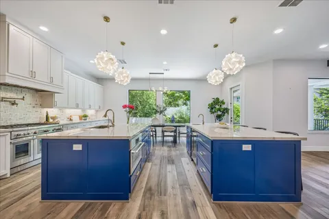 a kitchen with granite countertop a stove cabinets and wooden floor