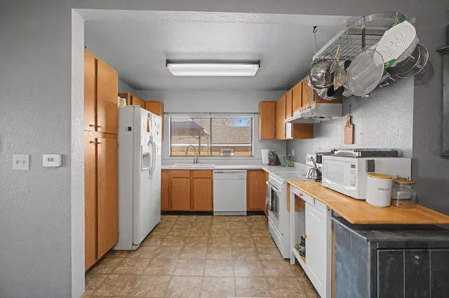 a kitchen with stainless steel appliances granite countertop a sink a stove and refrigerator