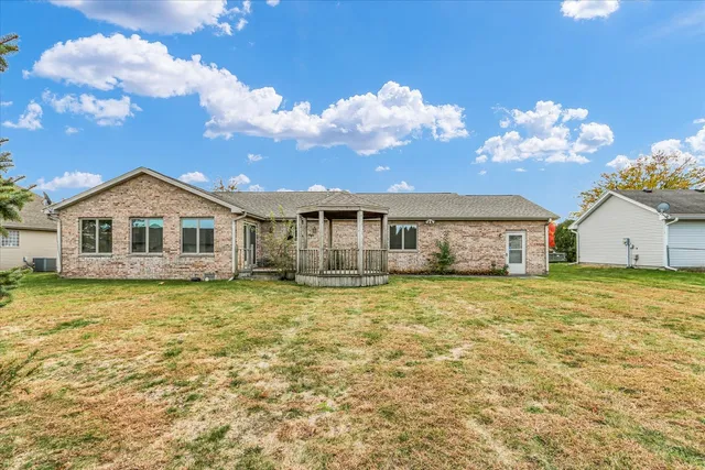 a yellow and red white house sitting next to a yard