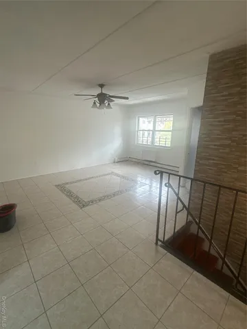 an empty room with windows and ceiling fan
