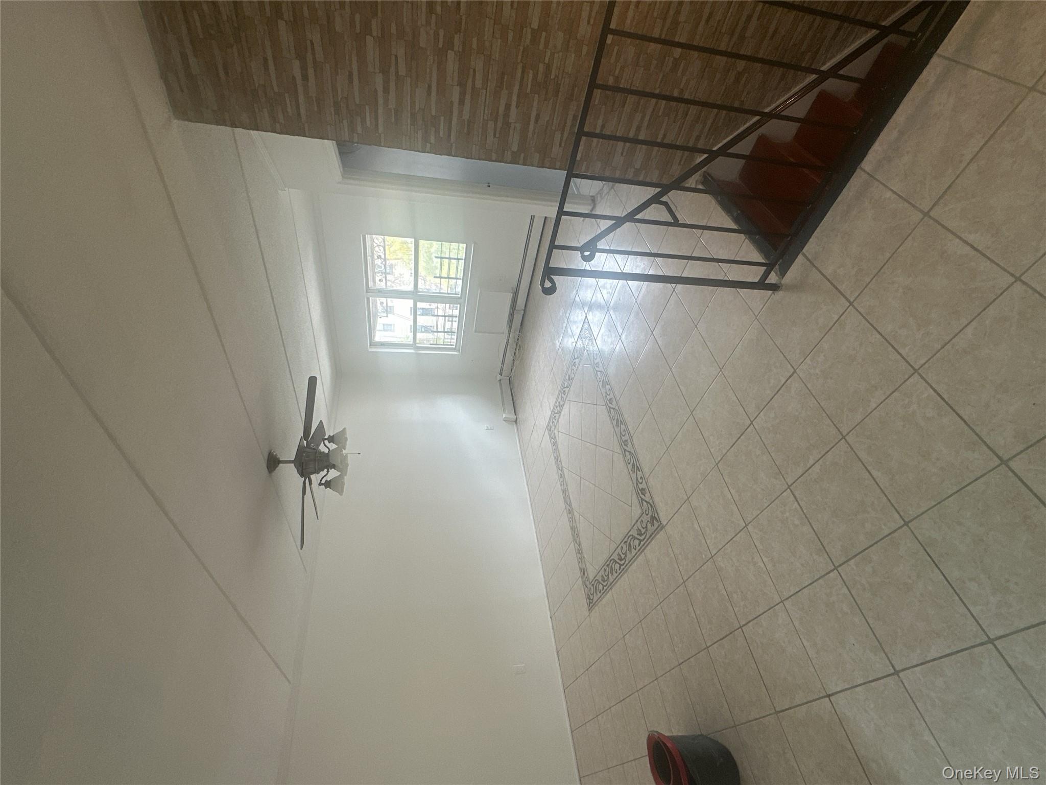 43 Menahan Street, Unit 2 Brooklyn, NY 11221 - Photo 2 of 5 an empty room with windows and ceiling fan