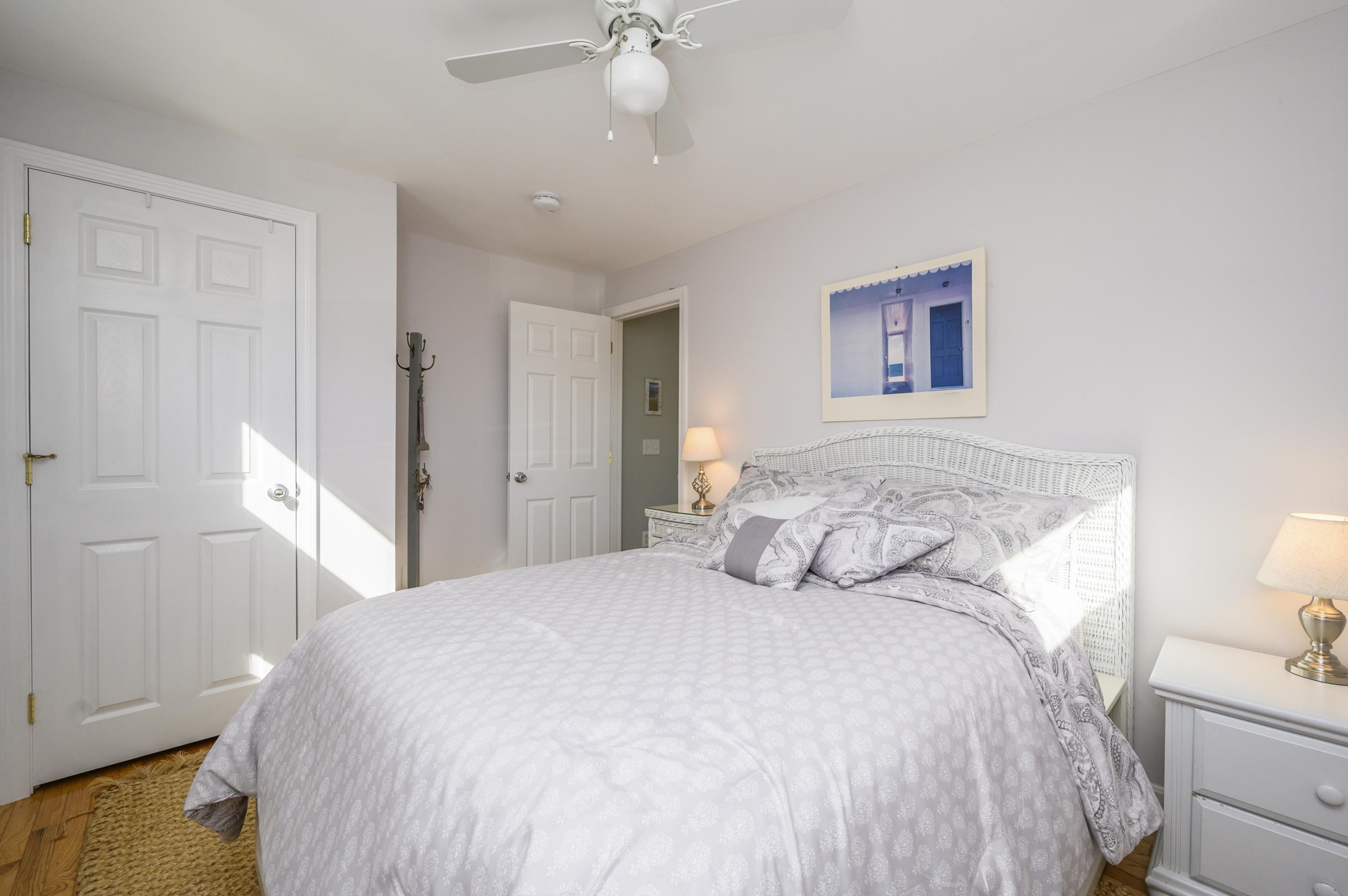 27 Locust Road, Unit 2 Eastham, MA 02642 - Photo 14 of 26 a bedroom with a bed and a chandelier