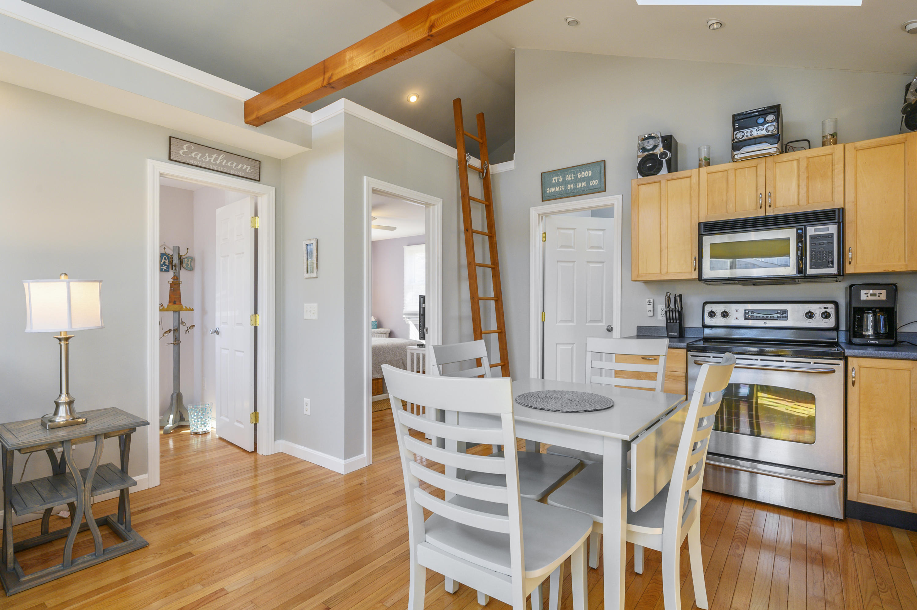 27 Locust Road, Unit 2 Eastham, MA 02642 - Photo 4 of 26 a kitchen with stainless steel appliances granite countertop a stove top oven a sink dishwasher and a table with chairs