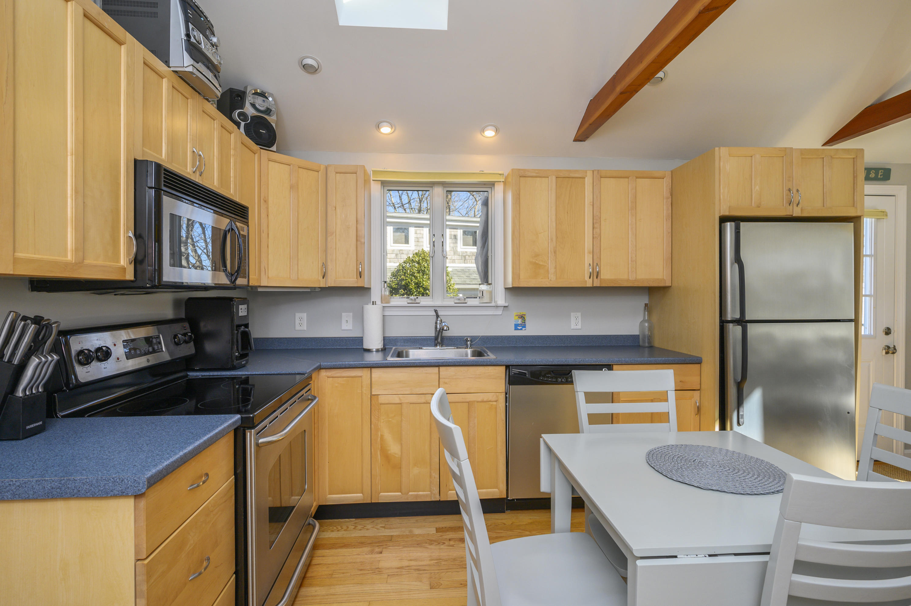 27 Locust Road, Unit 2 Eastham, MA 02642 - Photo 7 of 26 a kitchen with stainless steel appliances granite countertop a sink a stove a refrigerator cabinets and a dining table