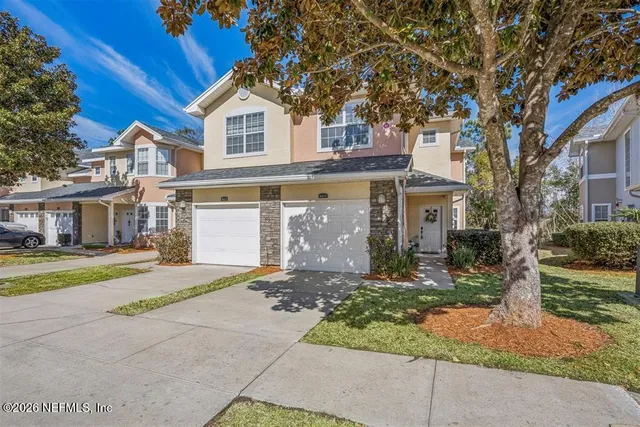 a front view of a house with a garden and trees