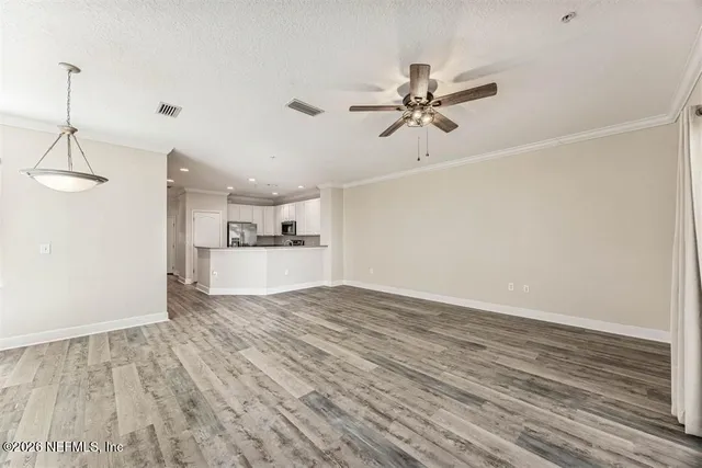 a view of a kitchen with wooden floor and a ceiling fan