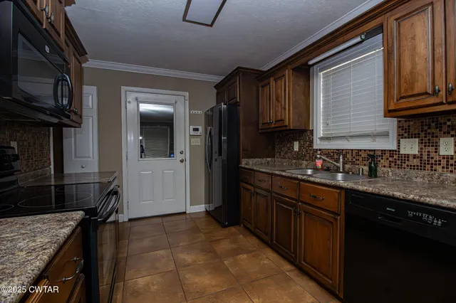 a kitchen with granite countertop a sink stove and cabinets