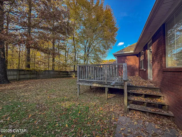 a backyard of a house with barbeque oven and wooden fence