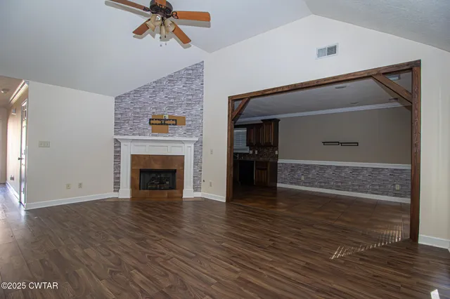 a view of a livingroom with wooden floor and a ceiling fan