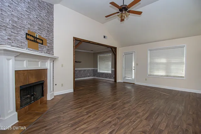 a view of empty room with wooden floor and fireplace