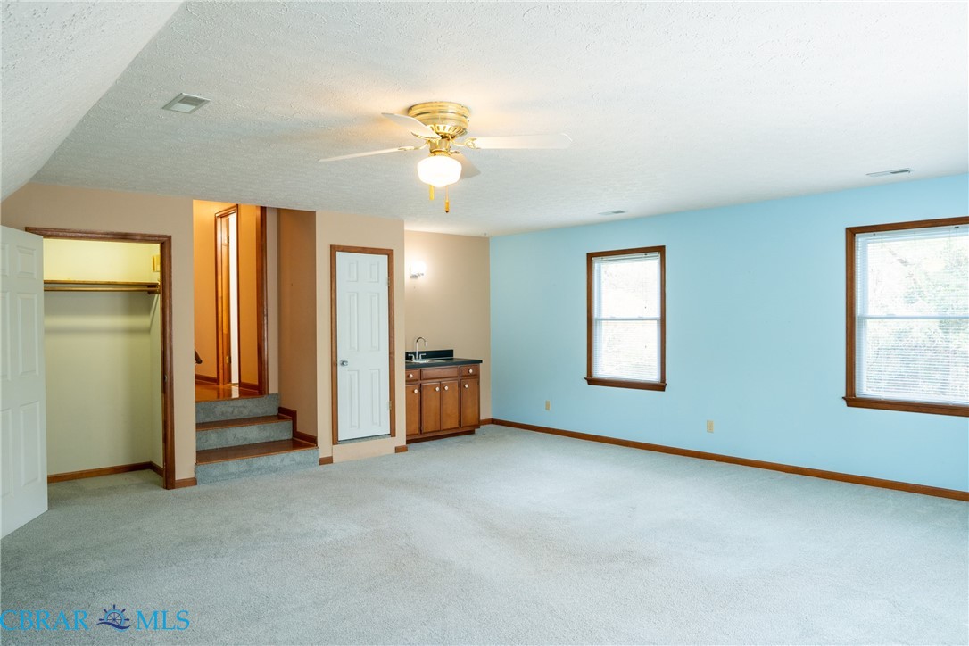 2847 Decatur Drive Hayes, VA 23072 - Photo 18 of 30 featuring a closet, a textured ceiling, light carpet, and a ceiling fan
