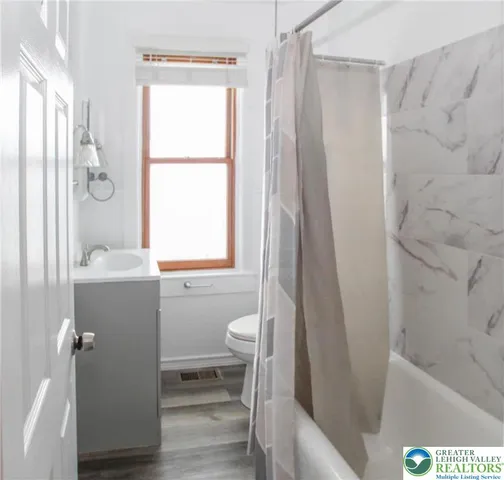 a bathroom with a bathtub a sink and a window