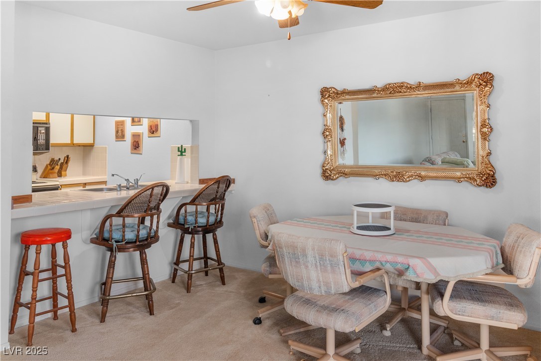 1928 Las Palmas Lane, Unit 228 Laughlin, NV 89029 - Photo 11 of 77 Dining area with ceiling fan and carpet flooring