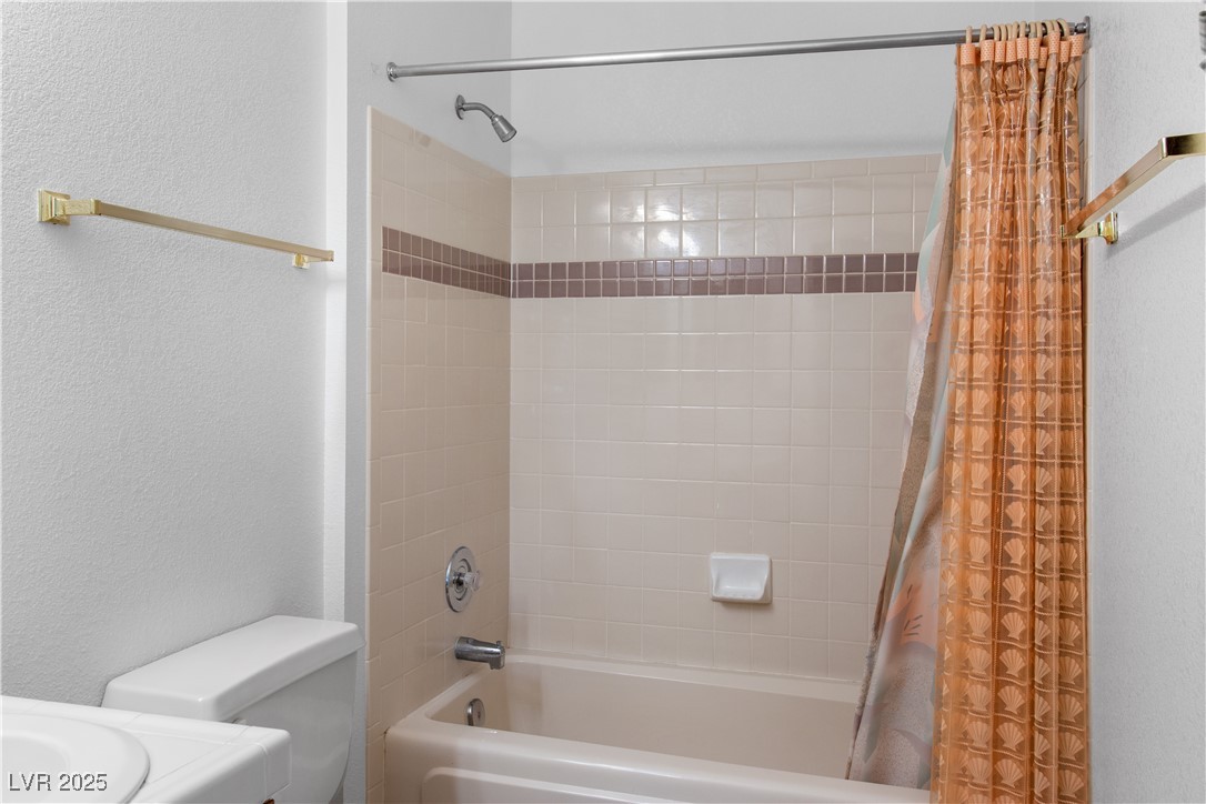 1928 Las Palmas Lane, Unit 228 Laughlin, NV 89029 - Photo 22 of 77 Hall Bathroom featuring shower / bath combo, a textured wall, and toilet