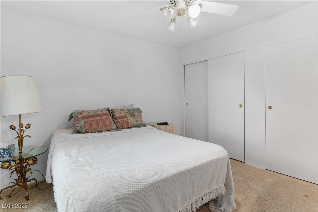 1928 Las Palmas Lane, Unit 228 Laughlin, NV 89029 - Photo 26 of 77 Primary Bedroom with light colored carpet, a closet, and ceiling fan