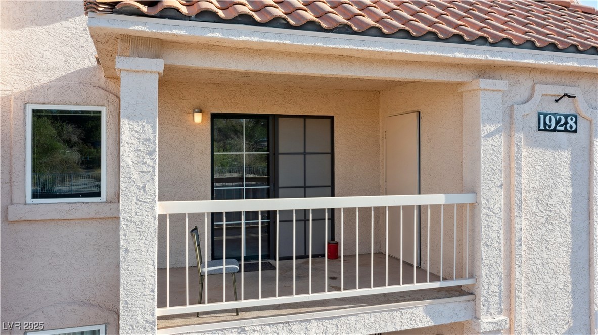 1928 Las Palmas Lane, Unit 228 Laughlin, NV 89029 - Photo 45 of 77 View of covered balcony with access to Living room and Dining area featuring stucco siding and a tile roof