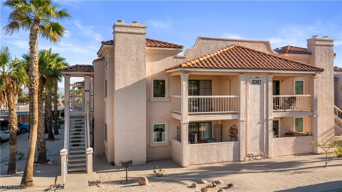 1928 Las Palmas Lane, Unit 228 Laughlin, NV 89029 - Photo 55 of 77 Back of house with stucco siding, a tiled roof, a balcony, and a chimney