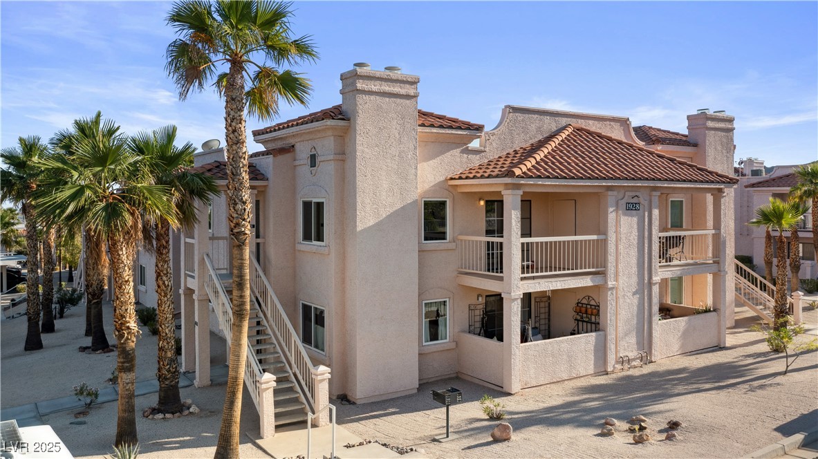 1928 Las Palmas Lane, Unit 228 Laughlin, NV 89029 - Photo 56 of 77 Back of house with stucco siding, a balcony, stairs, and a chimney