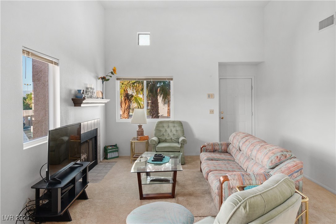 1928 Las Palmas Lane, Unit 228 Laughlin, NV 89029 - Photo 7 of 77 Carpeted living room featuring a towering ceiling and a tile fireplace