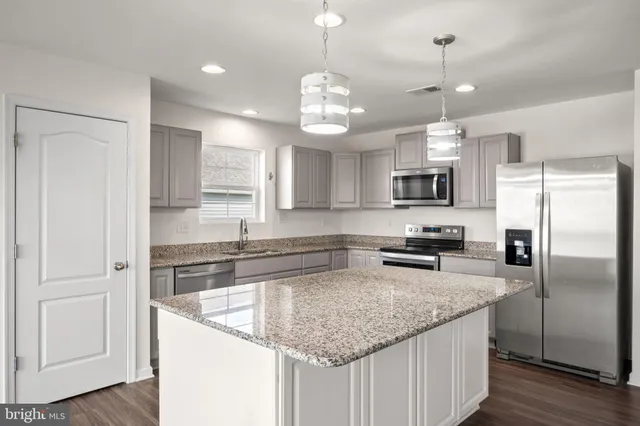 a kitchen with a center island and stainless steel appliances