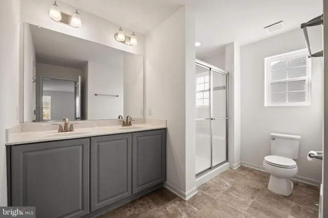 a spacious bathroom with a toilet a sink and mirror