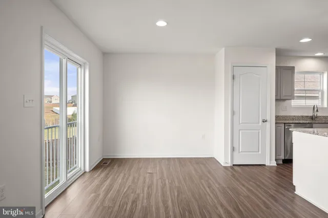 a view of a kitchen with wooden floor and a window