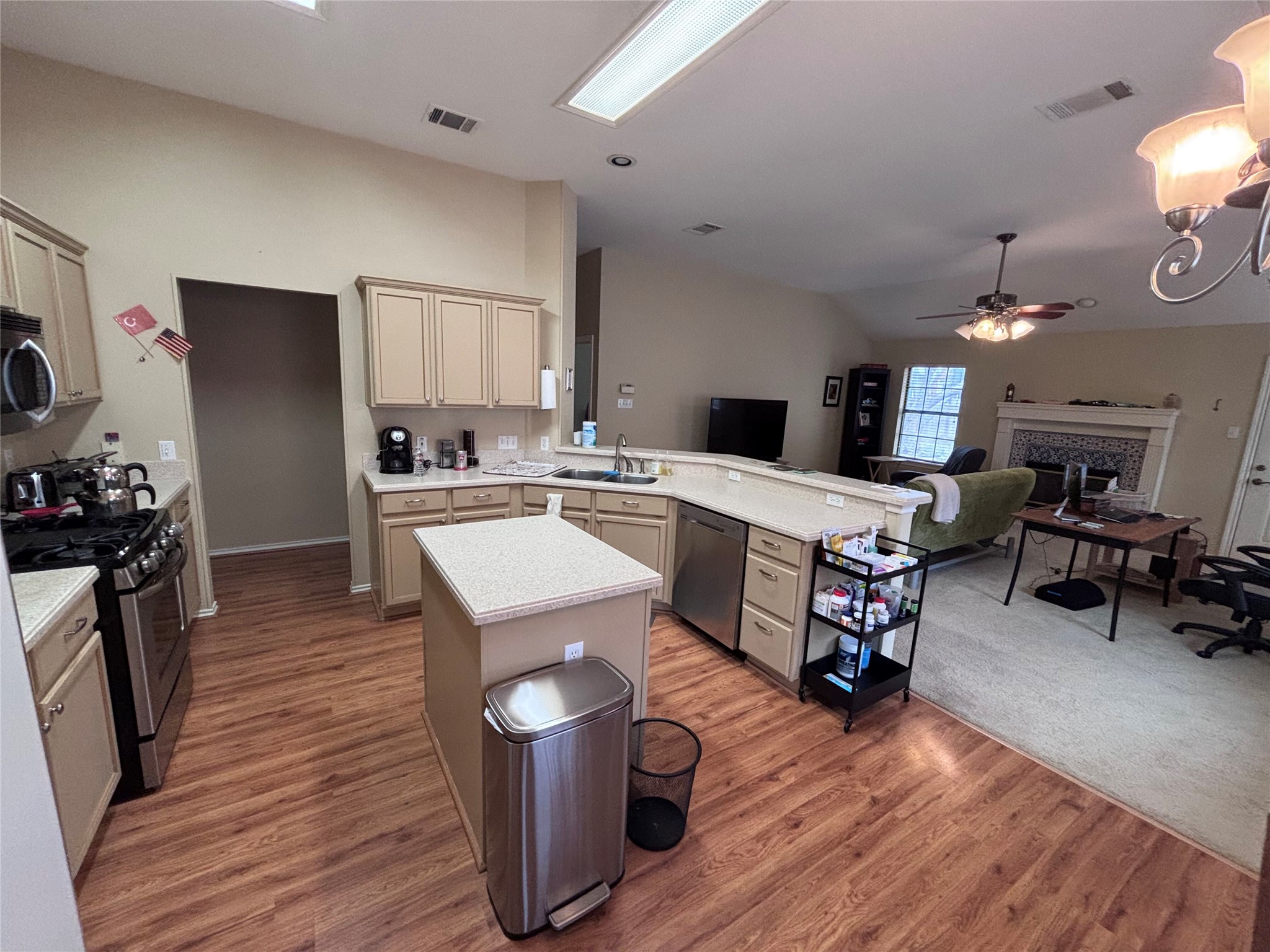 1316 Mesquite Road Cedar Park, TX 78613 - Photo 17 of 24 An inviting kitchen with wood flooring and stainless steel appliances flows seamlessly into the living space, perfect for modern living.