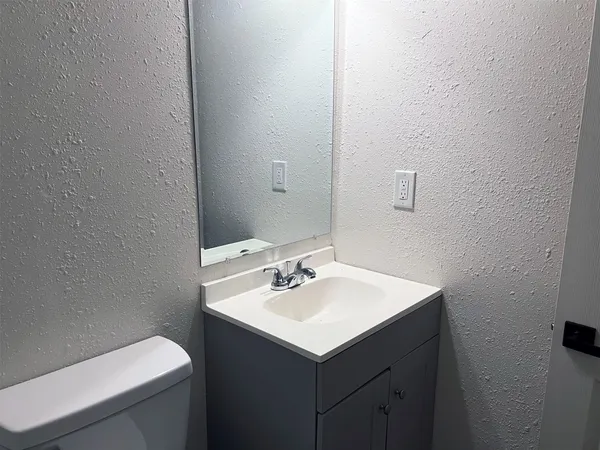a bathroom with a sink toilet and mirror